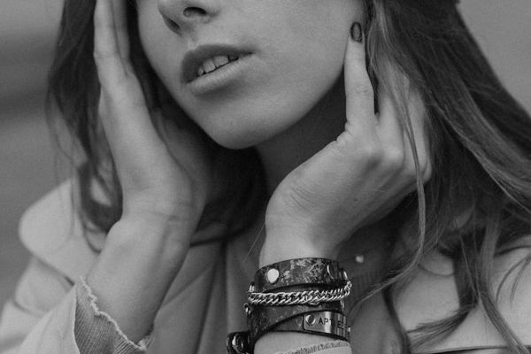 A person sitting in a calm, meditative pose in a minimalist room.